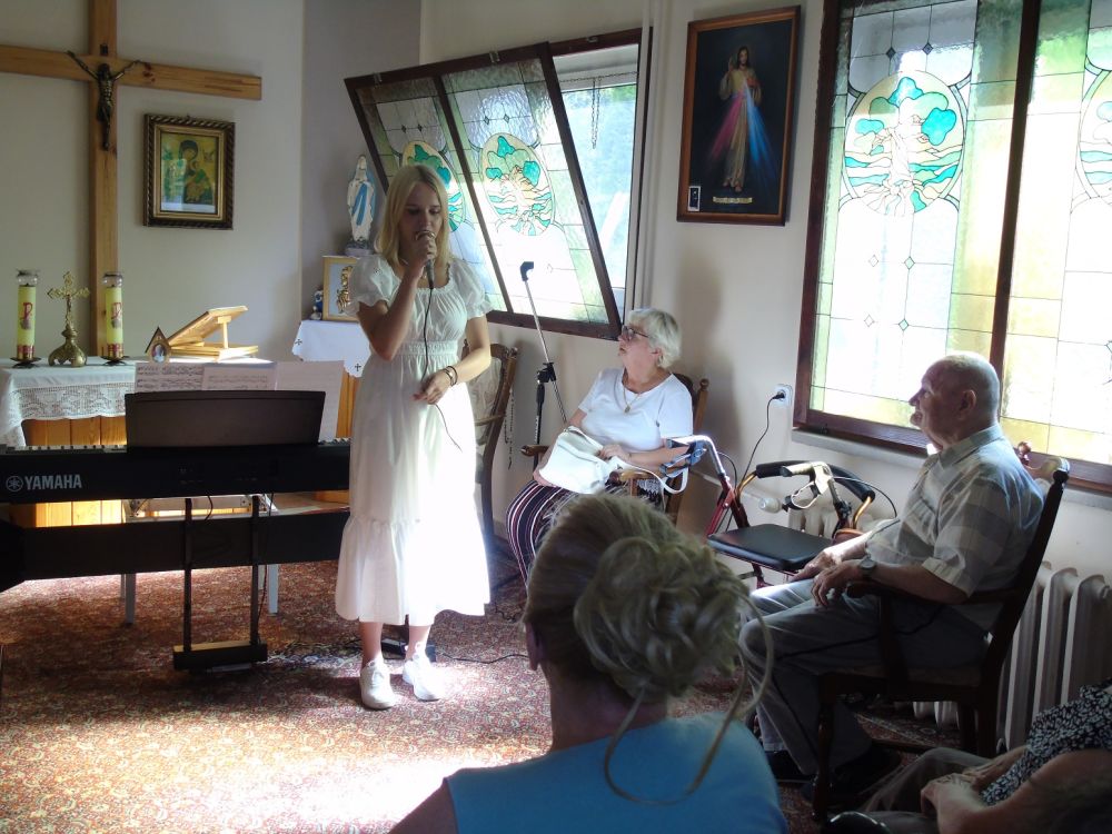 Pianistka stoi z mikrofonem w kaplicy