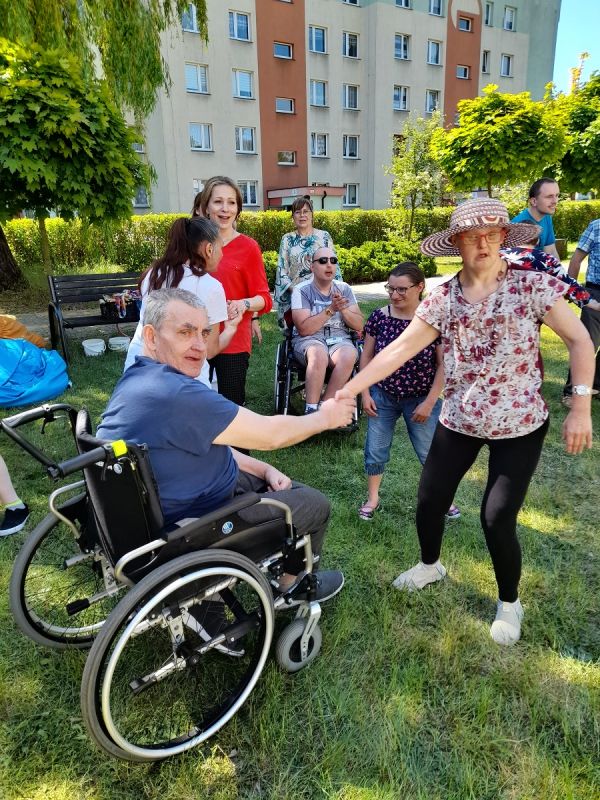 Mieszkaniec na wózku inwalidzkim  podczas tańców z podopiecznymi PŚDS 