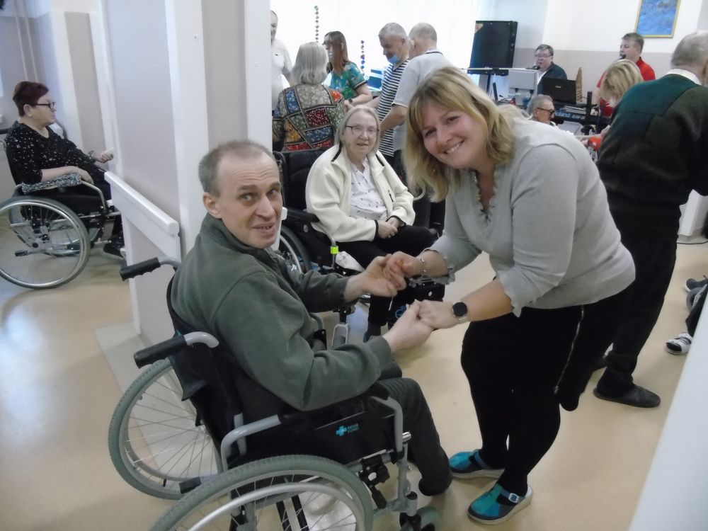 Terapeuta z mieszkańcem na wózku inwalidzkim podczas tańca